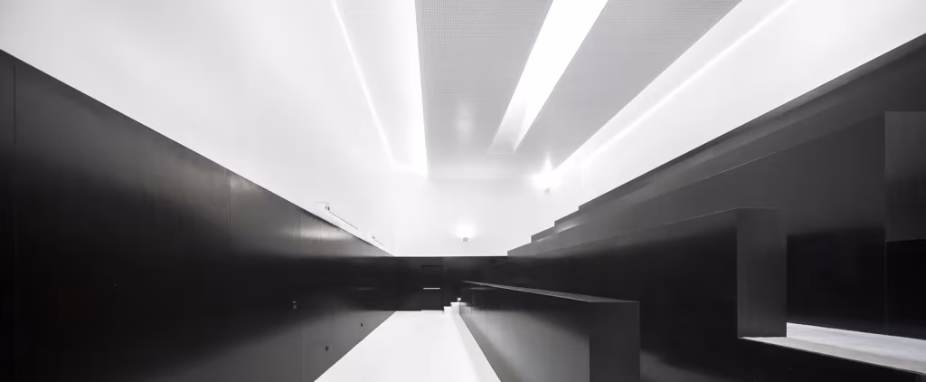 Interior en blanco y negro de la ESTIG de Beja con lucernarios longitudinales que reparten la luz cenital