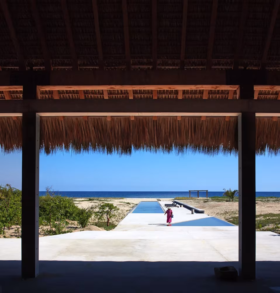 Porche de cubierta de palma abierto al mar y al estanque alargado de la Casa Wabi, en la costa de Oaxaca