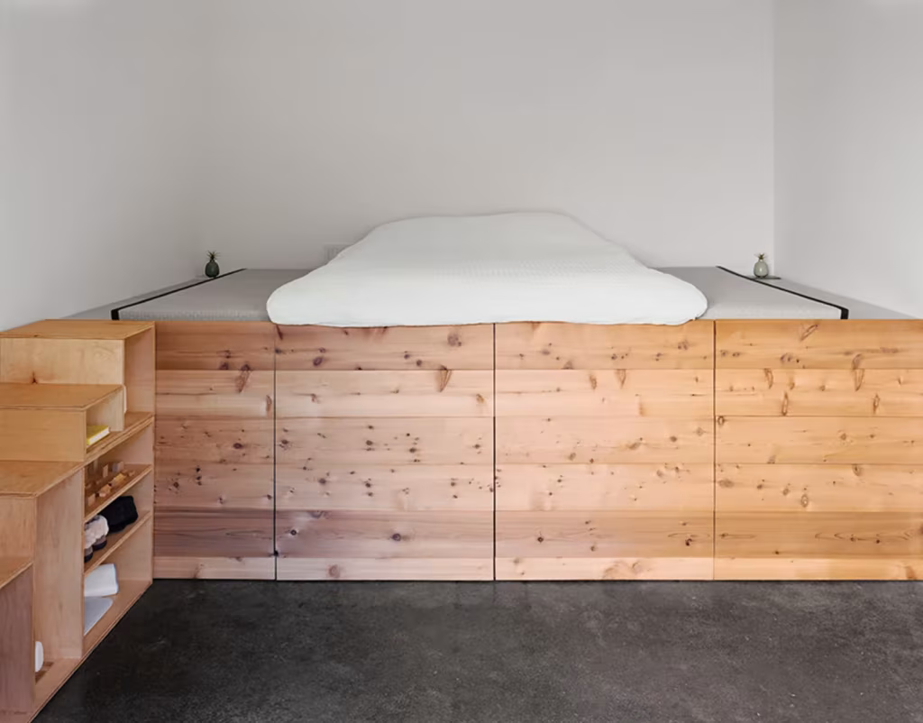 Shotwell Residence de Todd Davis Dormitorio Cama sobre una plataforma de madera con cajones y suelo de hormigón pulido en la Shotwell Residence