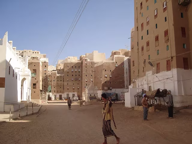Plaza de Shibam con vecinos y casas-torre de adobe de varias alturas, en Yemen