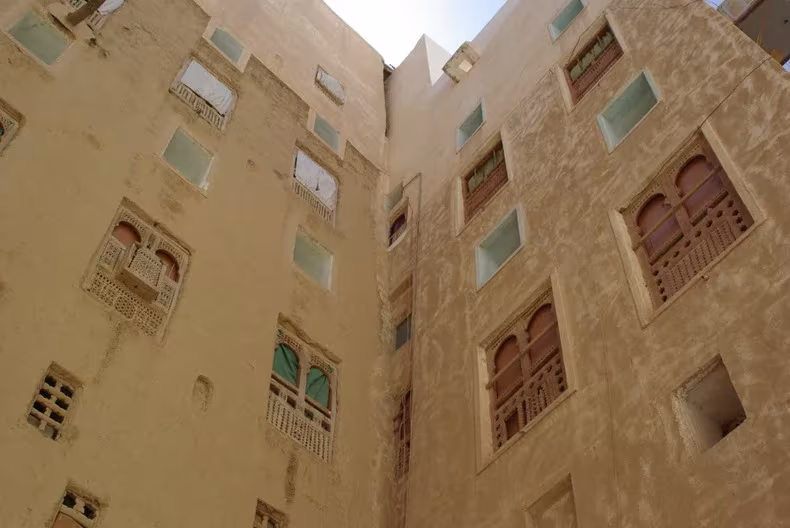 Fachadas de adobe de Shibam vistas desde abajo, con ventanas de madera y pequeños huecos de ventilación