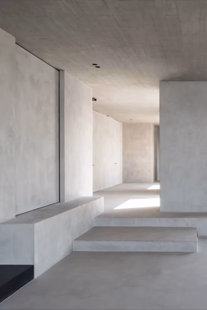 Corredor del C Penthouse con peldaño y banco de obra en tonos grises de cal y hormigón pulido