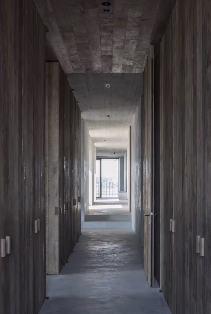 Pasillo revestido de madera envejecida con puertas ocultas y luz al fondo en el C Penthouse de Amberes