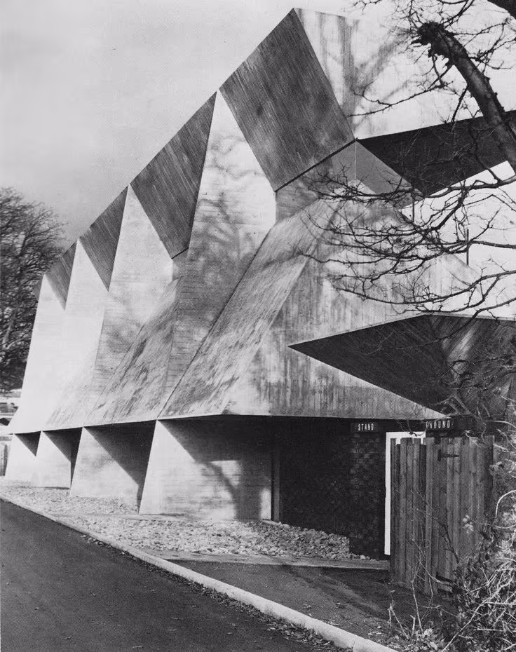Grada de Netherdale de Peter Womersley en blanco y negro, con la cubierta plegada sobre pórticos de hormigón