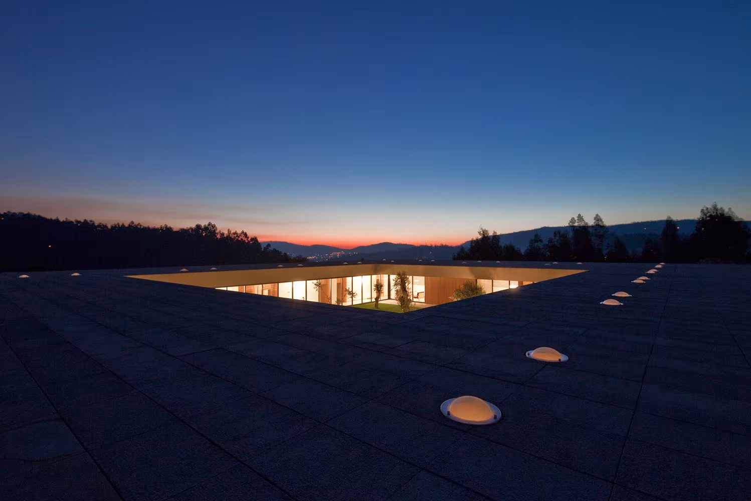 Cubierta de la Casa de Magalhães al atardecer con el patio abierto iluminado y claraboyas circulares