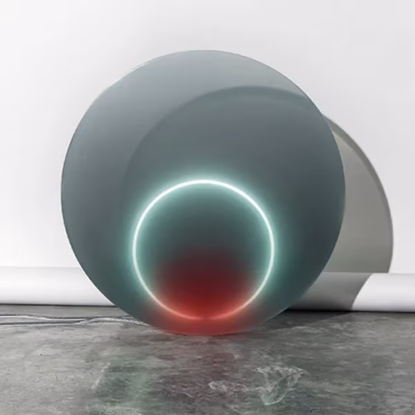 Discos de resina gris de la serie Dawn de Sabine Marcelis con un aro de luz blanca y reflejo rojo