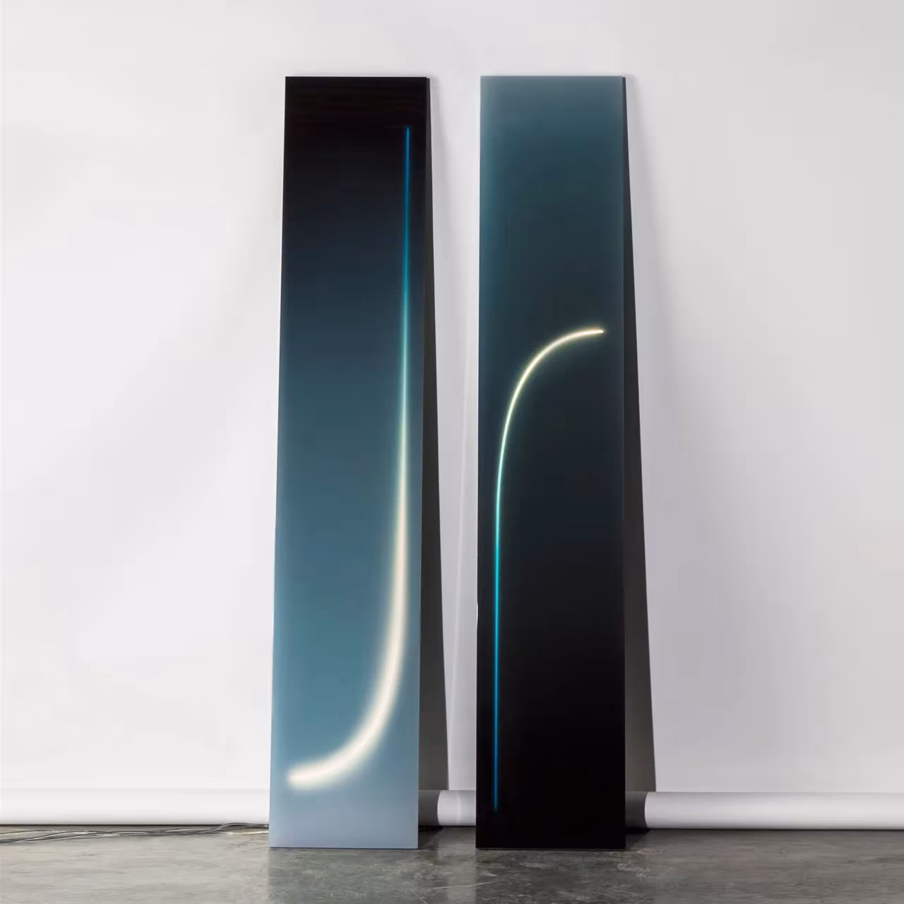Dos paneles verticales de la serie Dawn en degradado azul con líneas de neón curvas apoyados en la pared