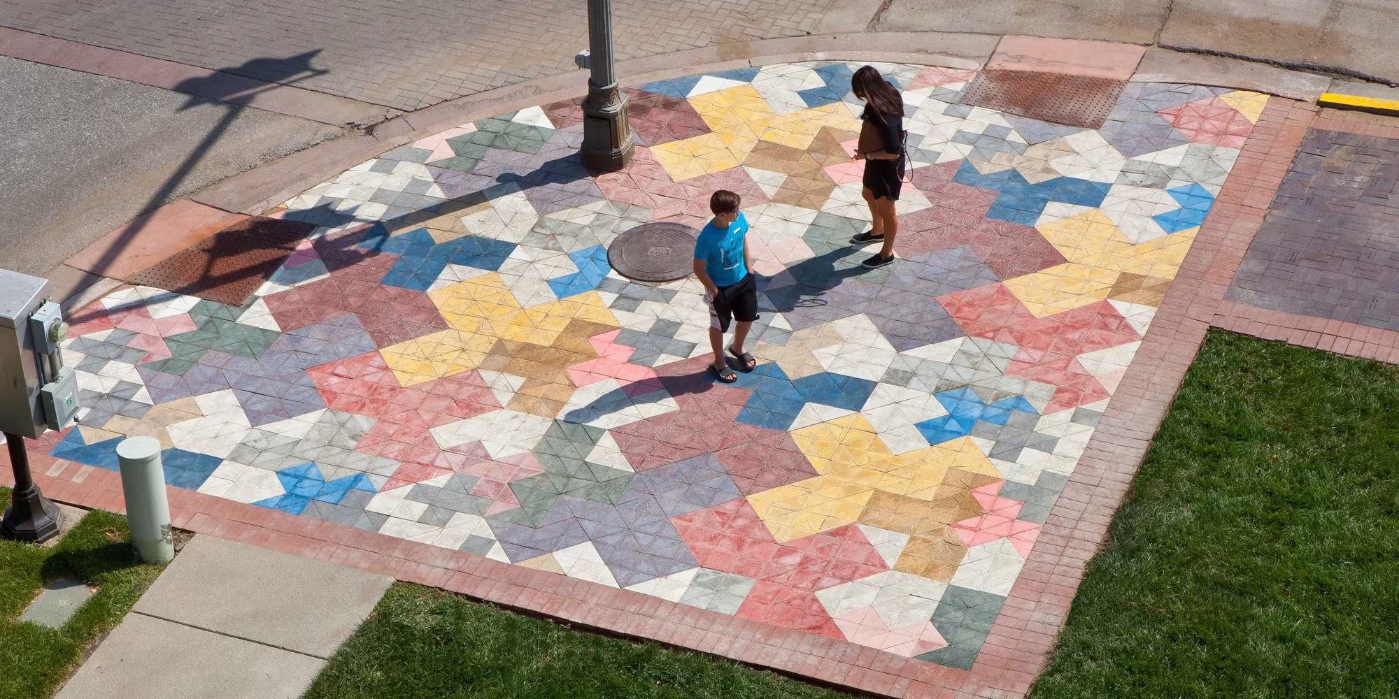 Instalación Theoretical Foyer de Cody Hoyt en Columbus, alfombra de baldosas de colores con niños jugando