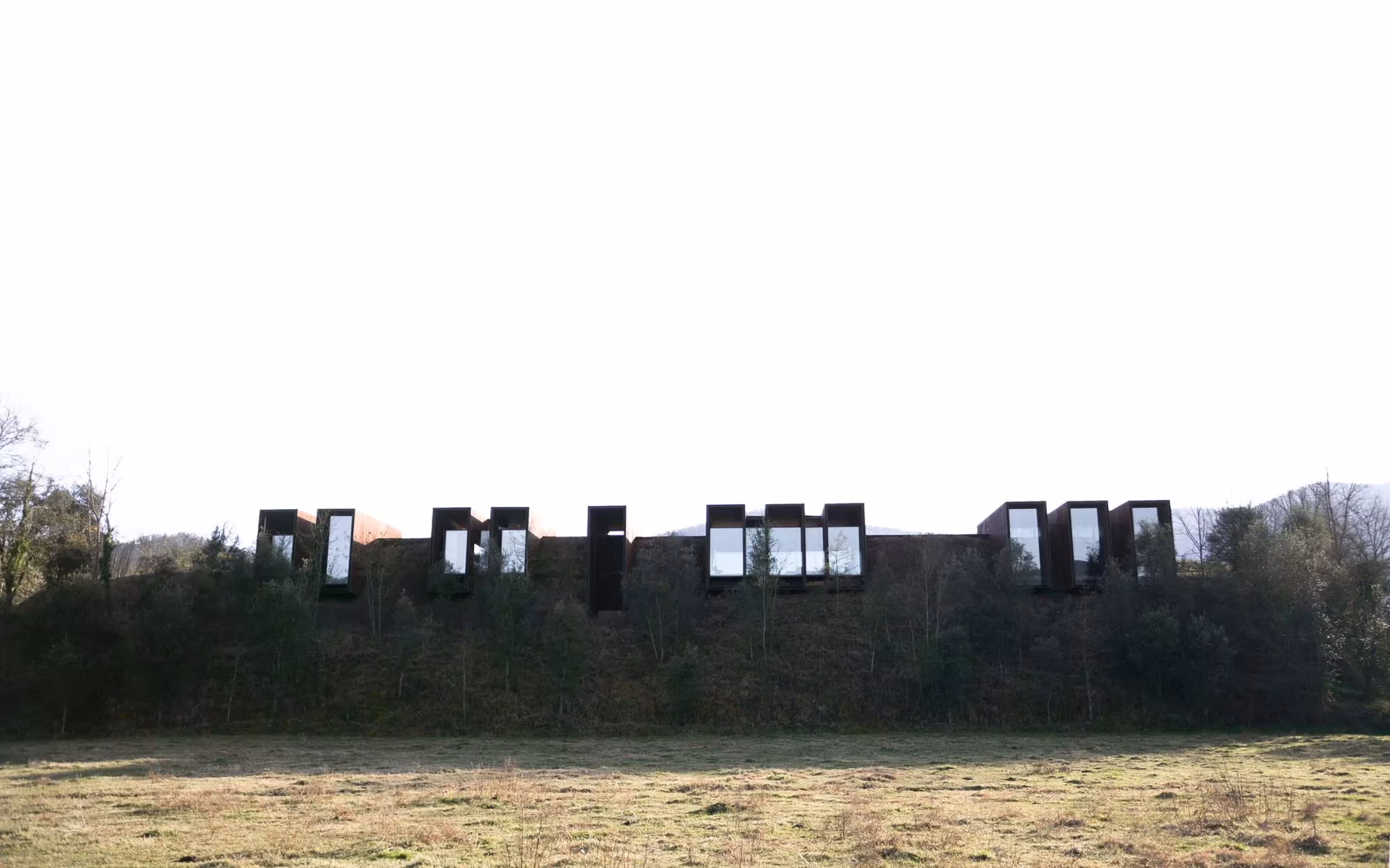 Casa Horizonte de RCR semienterrada, con una hilera de lucernarios que sobresalen del terreno en la Garrotxa
