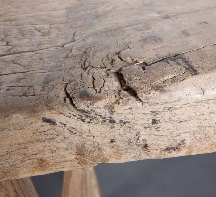 Detalle de la pátina y la veta agrietada de un mueble antiguo de madera maciza
