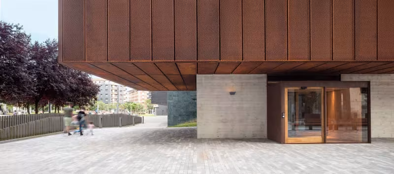 Escuela de Música de Zubiaur en Amorebieta-Etxano, volumen de chapa cobriza volado sobre una entrada acristalada