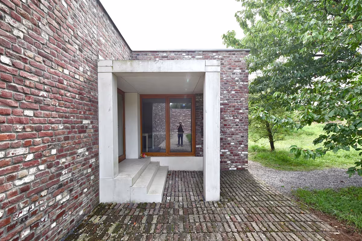 Acceso de hormigón blanco escalonado en un muro de ladrillo del museo de Siza y Finsterwalder, Hombroich