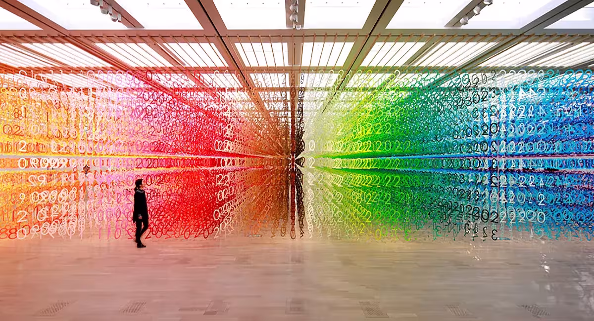 Forest of Numbers de Emmanuelle Moureaux, miles de números de papel de colores suspendidos con una persona dentro