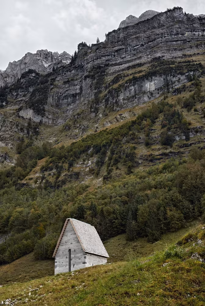 Capilla de hormigón de Wirmboden a los pies de una pared rocosa en el paisaje de montaña alpino