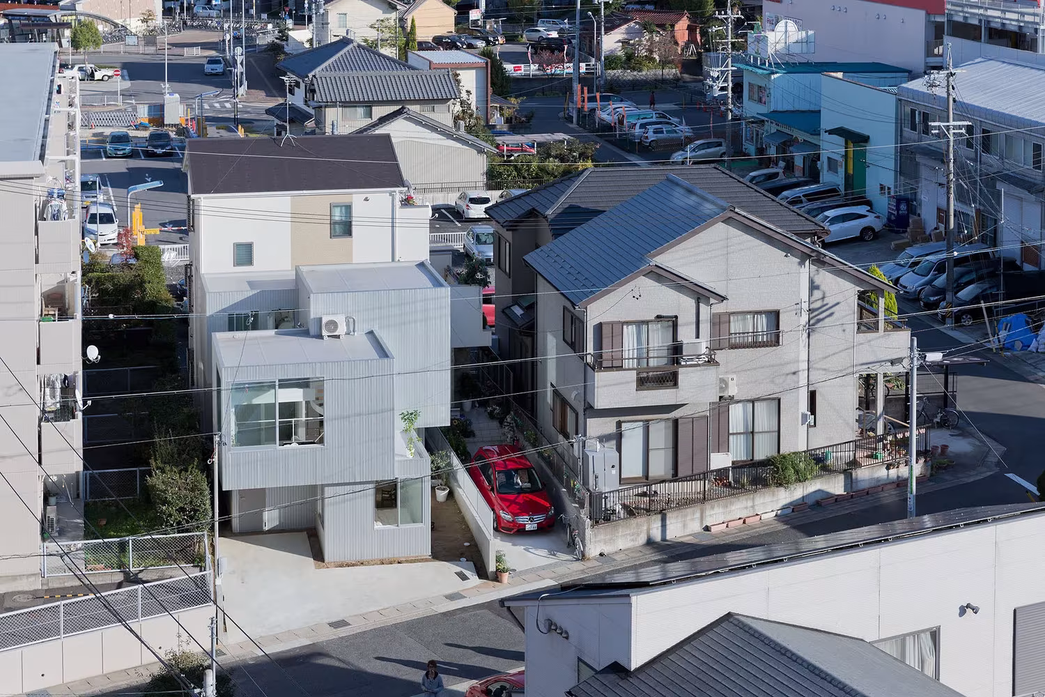Vista aérea de la Casa Chayagasaka entre viviendas bajas y aparcamientos de un barrio de Nagoya