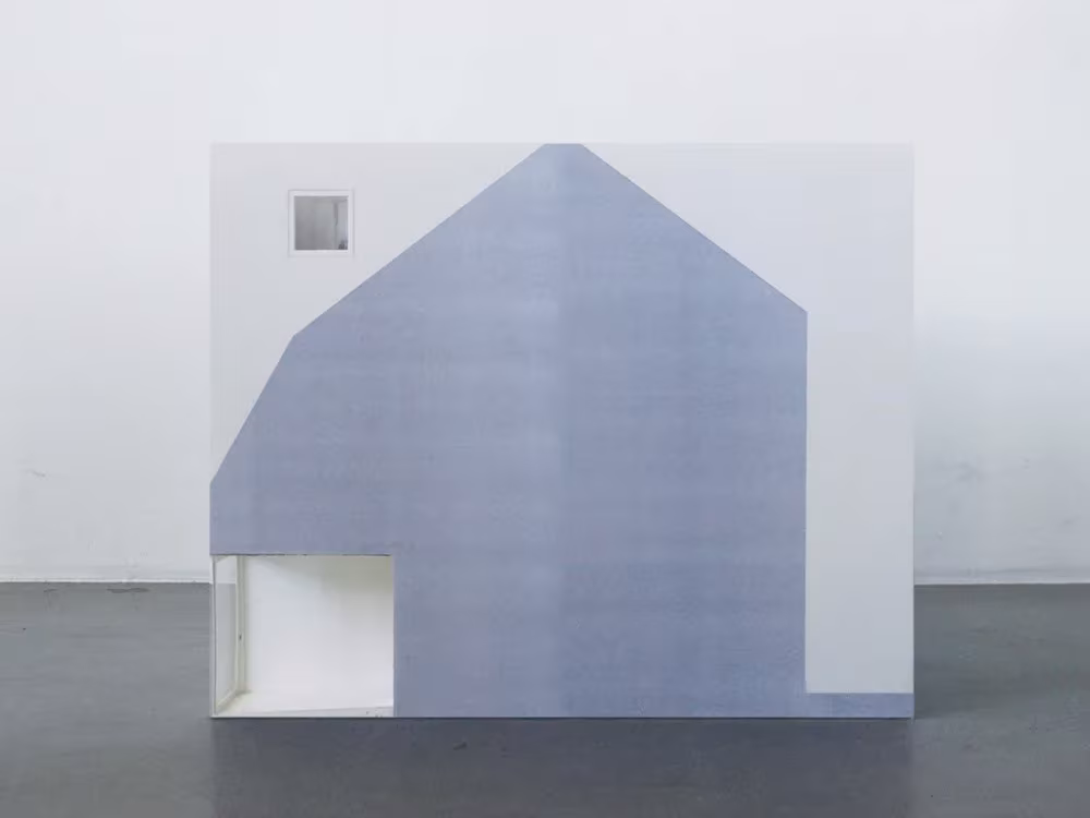 Maqueta de la Townhouse de Elding Oscarson, fachada lateral con silueta de casa a dos aguas en azul grisáceo