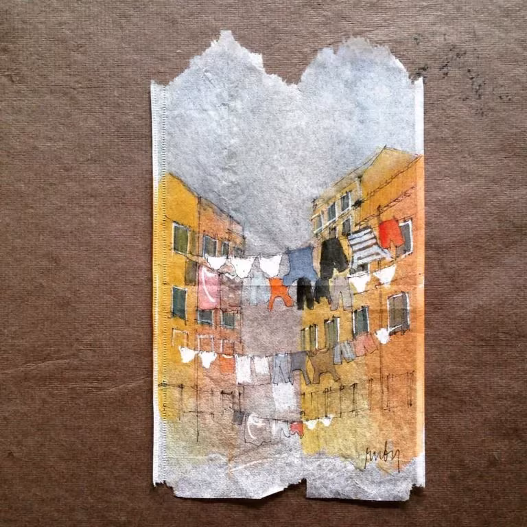 Bolsita de té pintada por Ruby Silvious con una calle de casas de colores y ropa tendida