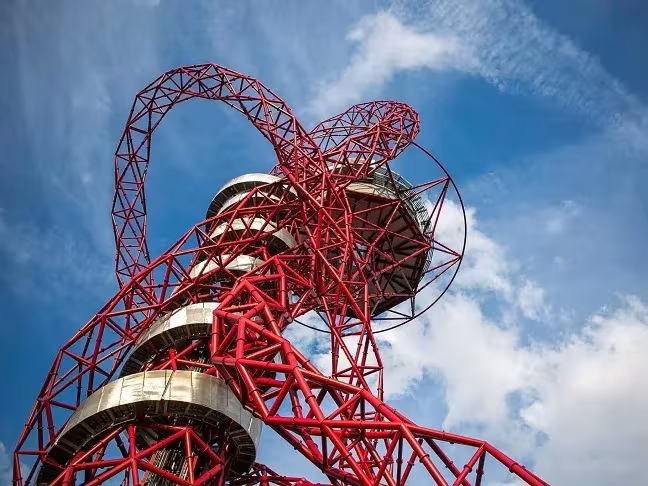 Estructura de acero rojo retorcido del ArcelorMittal Orbit de Anish Kapoor vista desde abajo contra el cielo