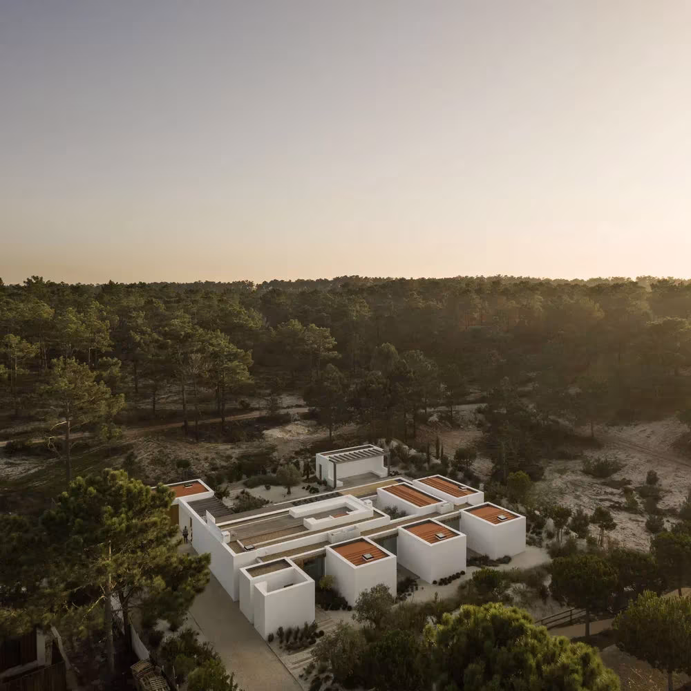 Vista aérea de Comporta 10 de Fragmentos de Arquitectura, volúmenes blancos dispersos entre pinares al atardecer