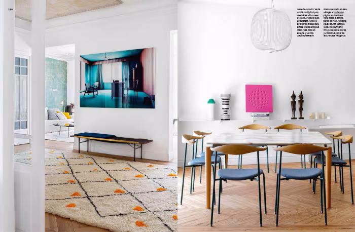 Doble página de AD España con un salón de gran cuadro azul y un comedor de sillas azules y mesa de roble en el piso de ÁBATON