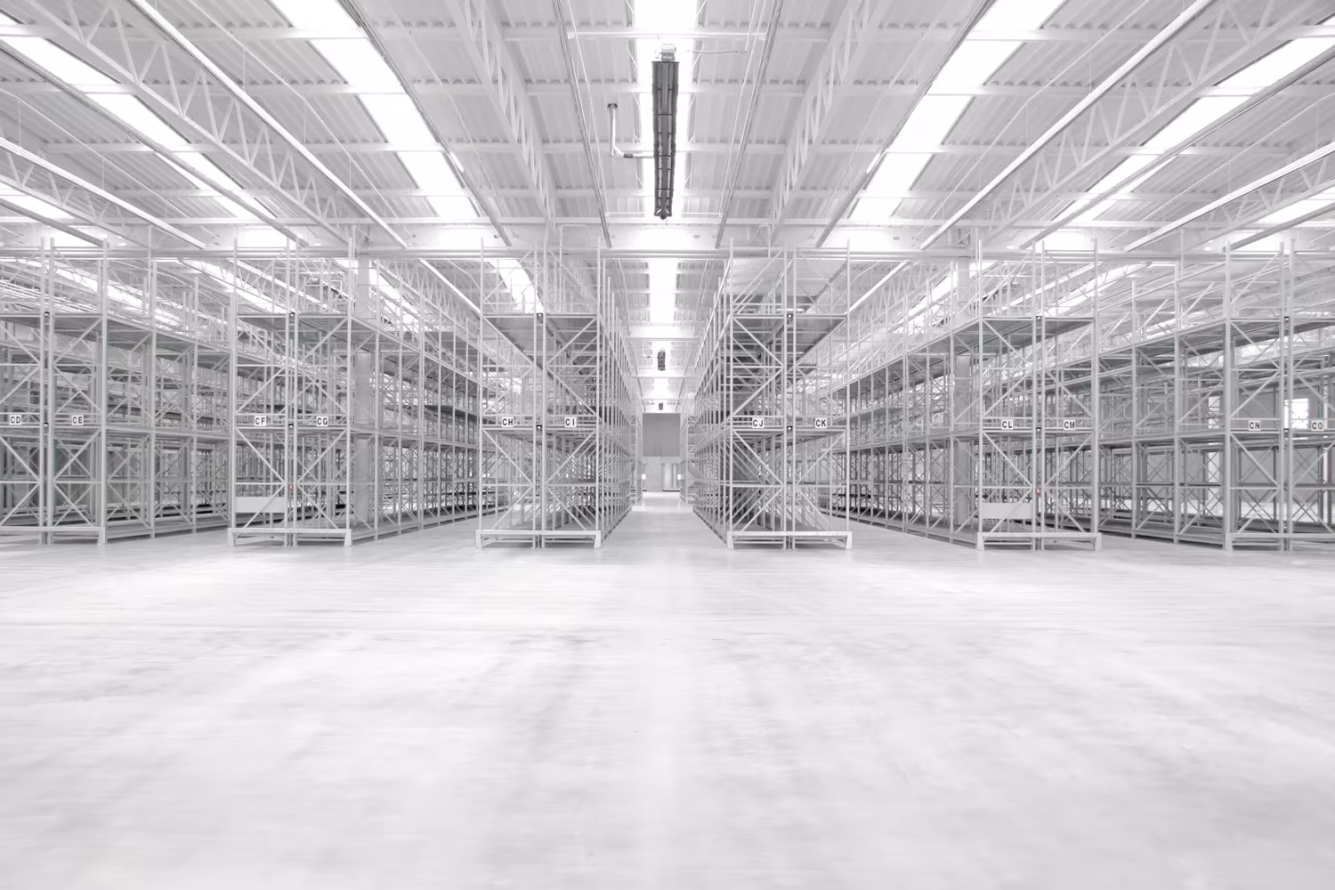 Perspectiva de la nave del pabellón de SANAA en el Vitra Campus con lucernarios y estanterías hacia el fondo