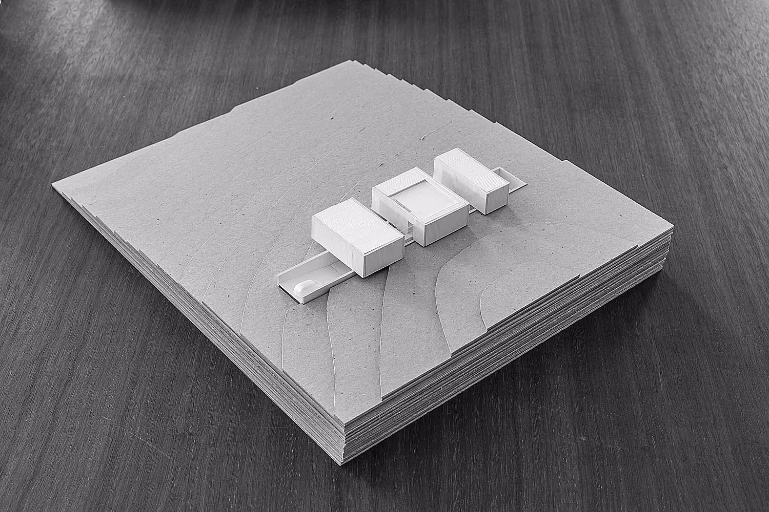 Maqueta de los tres volúmenes de Bosc d'en Pep Ferrer sobre la base del terreno en Formentera