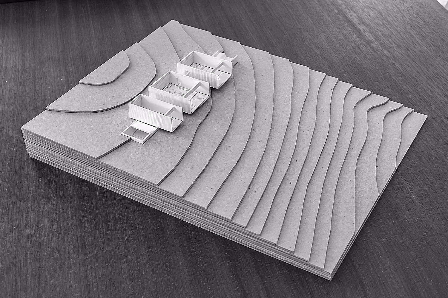 Maqueta con la planta de los volúmenes de Bosc d'en Pep Ferrer abierta sobre la topografía de Formentera