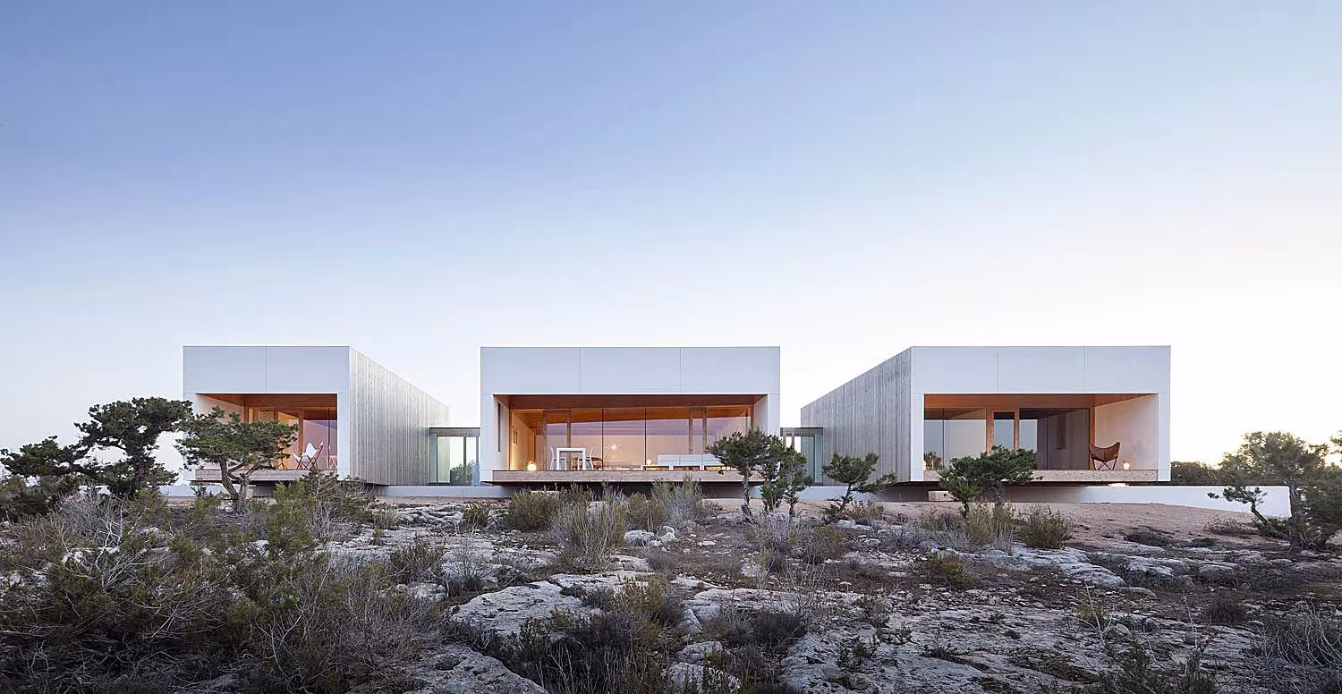 Tres volúmenes blancos con huecos abiertos sobre el terreno rocoso de Bosc d'en Pep Ferrer, en Formentera