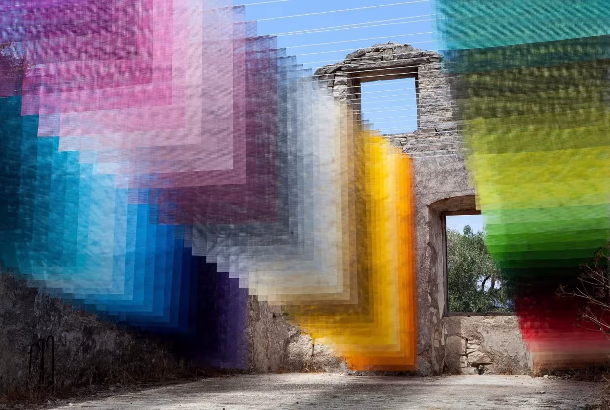 Instalación Kagkatikas Secret de Quintessenz, telas en degradados de colores dentro de un edificio en ruinas de Paxos