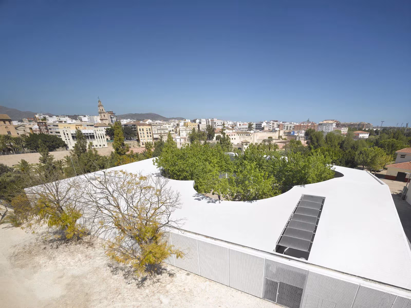 Cubierta ajardinada con lucernario y vistas a Gandía desde la Universidad Popular Infantil de Paredes Pedrosa