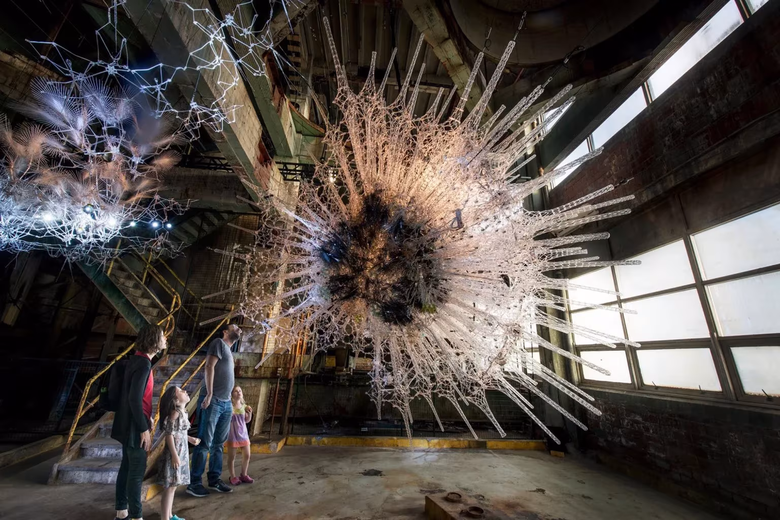 Instalación Astrocyte de Philip Beesley en Toronto: malla interactiva de filamentos luminosos con visitantes bajo ella