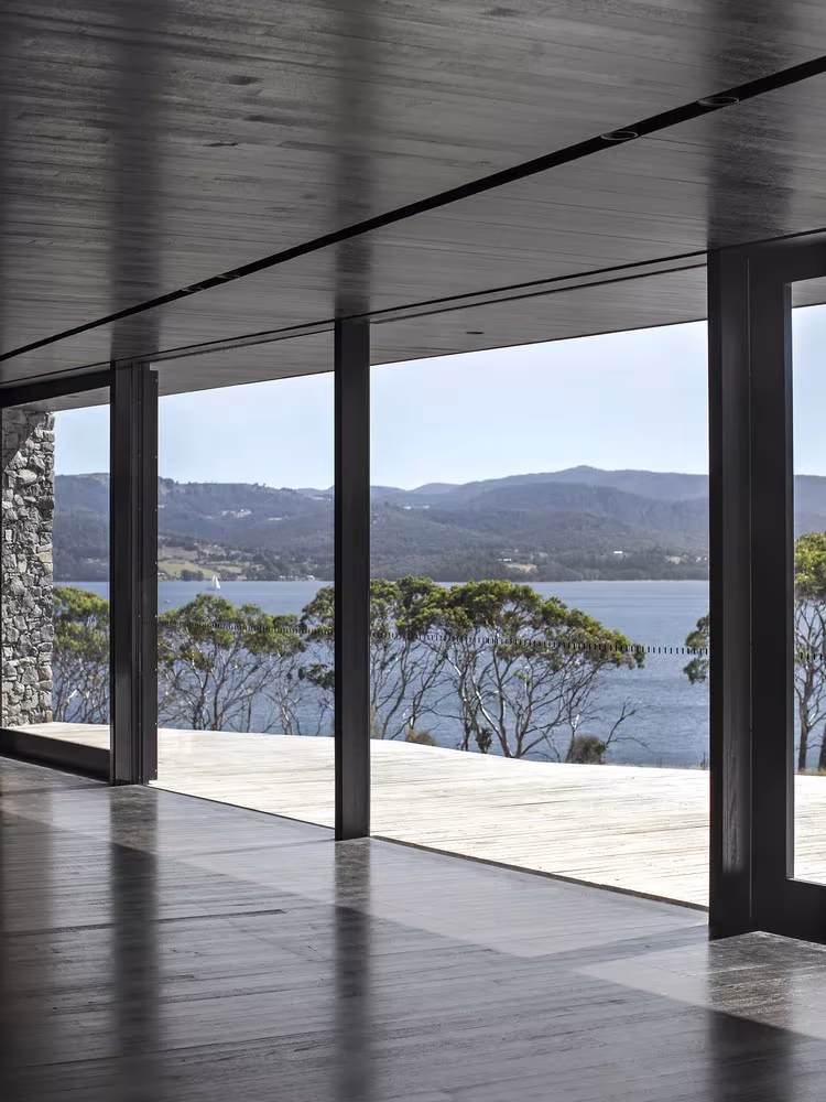 Salón con cristaleras de suelo a techo y vistas al estuario y las colinas en D'Entrecasteaux House, isla de Bruny
