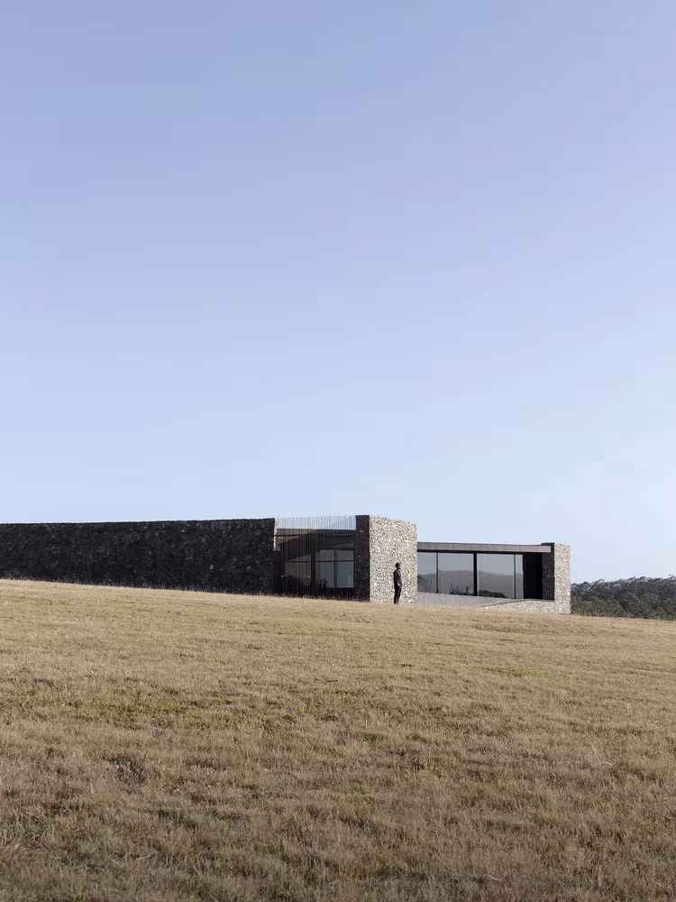 Volumen bajo de piedra y vidrio de D'Entrecasteaux House en el prado de la isla de Bruny