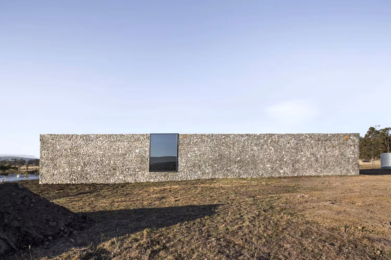 Fachada larga de gaviones de dolerita con una ventana en D'Entrecasteaux House, en la isla de Bruny