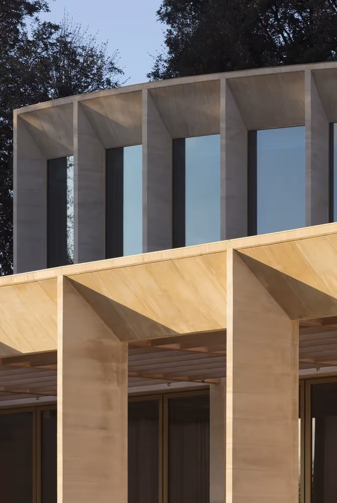 Detalle de contrafuertes de piedra y vidrio en el cuerpo superior del auditorio, de Níall McLaughlin Architects