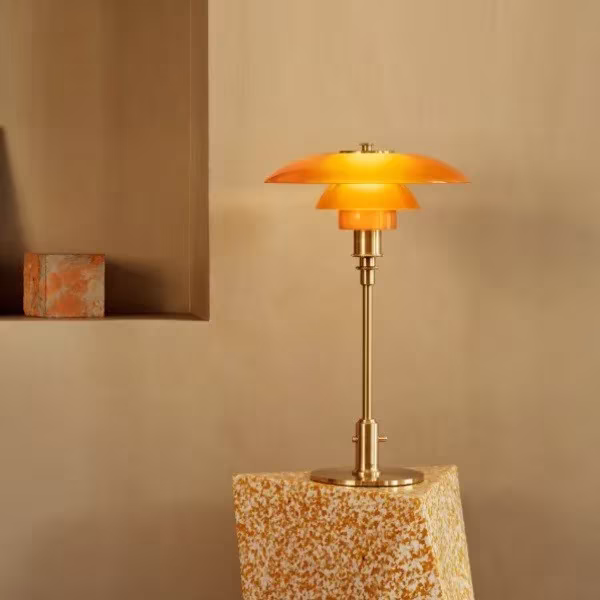 Lámpara de mesa PH 3/2 de Poul Henningsen en cristal ámbar y latón sobre un pedestal de piedra