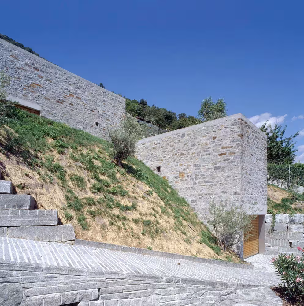 Casa Brione de Wespi de Meuron Romeo: dos cubos de piedra excavados en la ladera con escalera de lajas