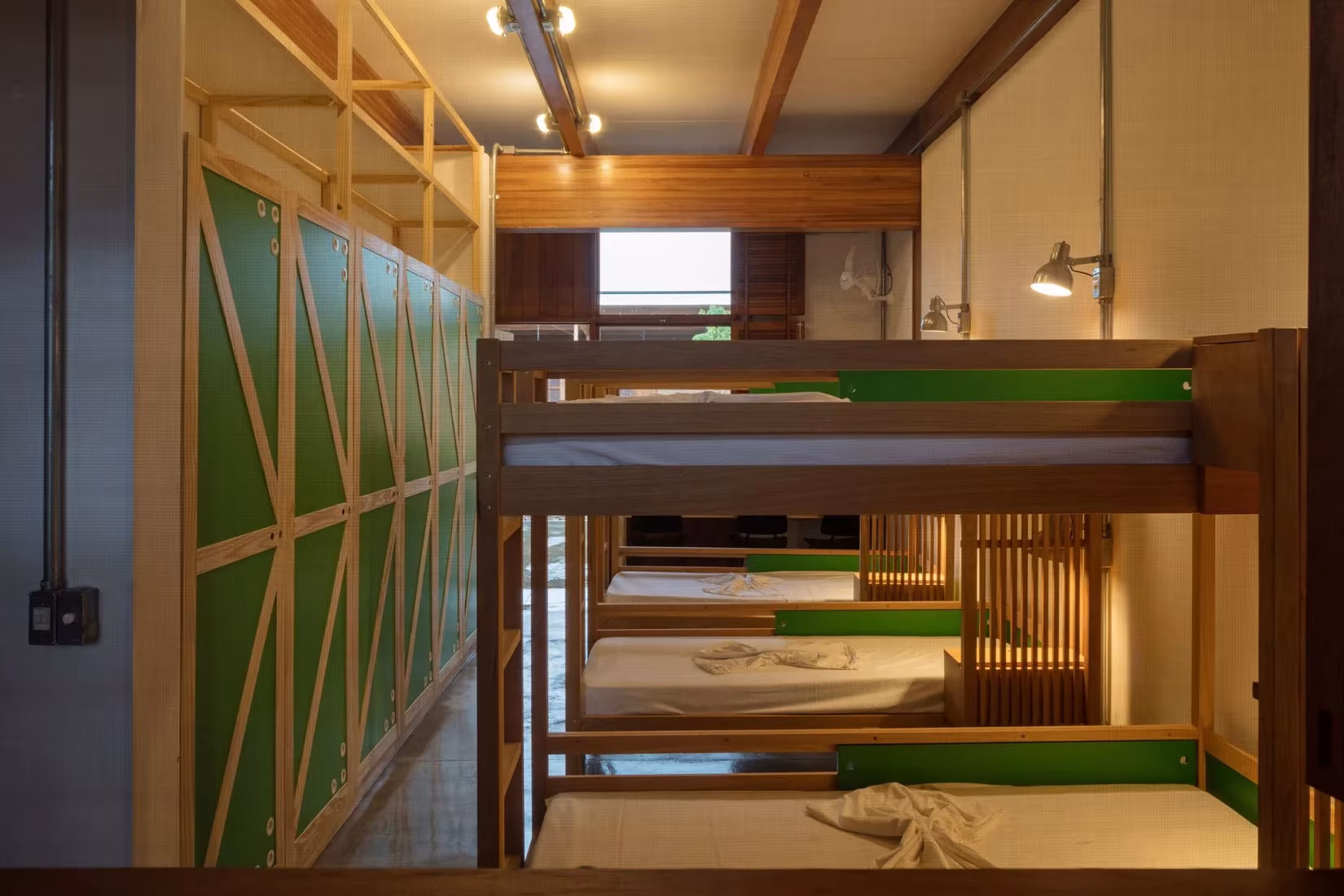 Dormitorio con literas de madera y paneles verdes en la residencia de la Ciudad de los niños de Canuanã