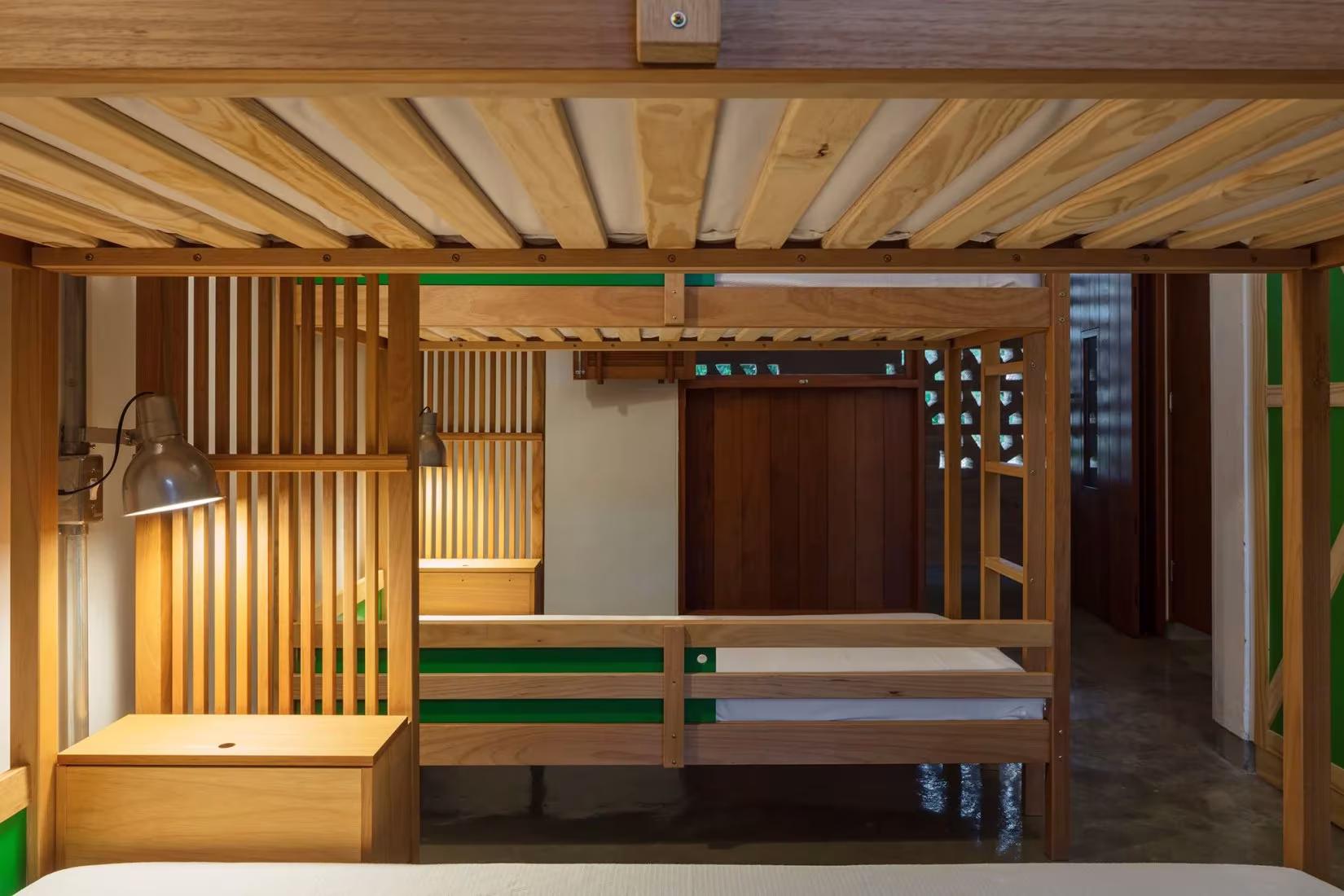Dormitorio de madera con celosía, literas y escritorio en la escuela de Canuanã de Rosenbaum y Aleph Zero