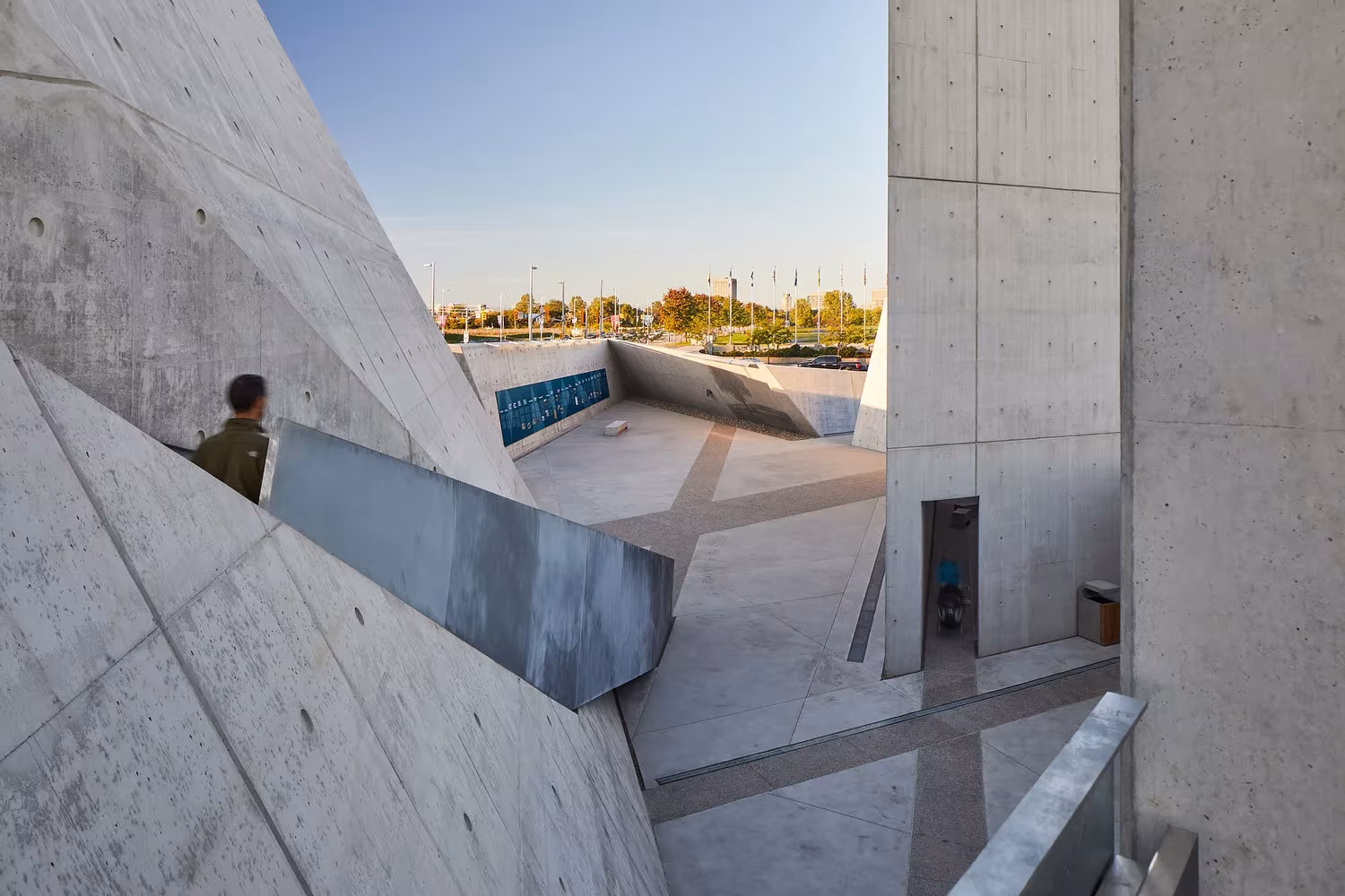 Visitante junto a un parapeto metálico entre muros de hormigón en el Monumento Nacional del Holocausto de Ottawa
