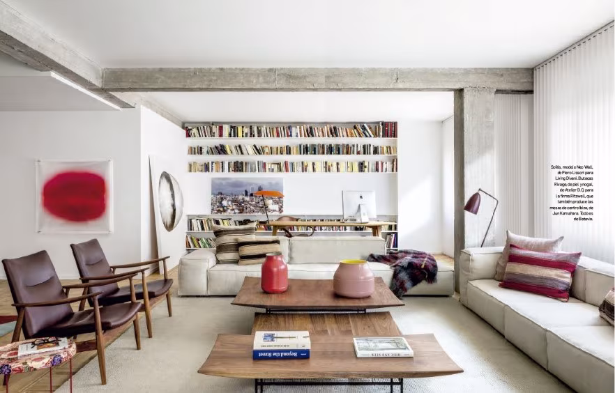 Salón con librería, sillones de madera y mesa de centro en Abajo las Barreras, reforma de Ábaton y BATAVIA
