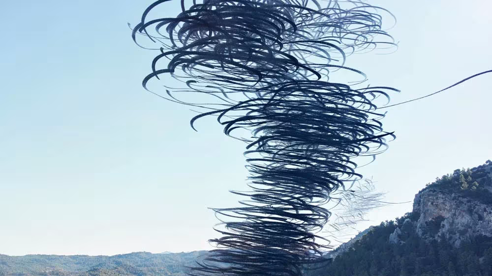 Torbellino azul oscuro de aves sobre un valle montañoso, cronofotografía de Xavi Bou