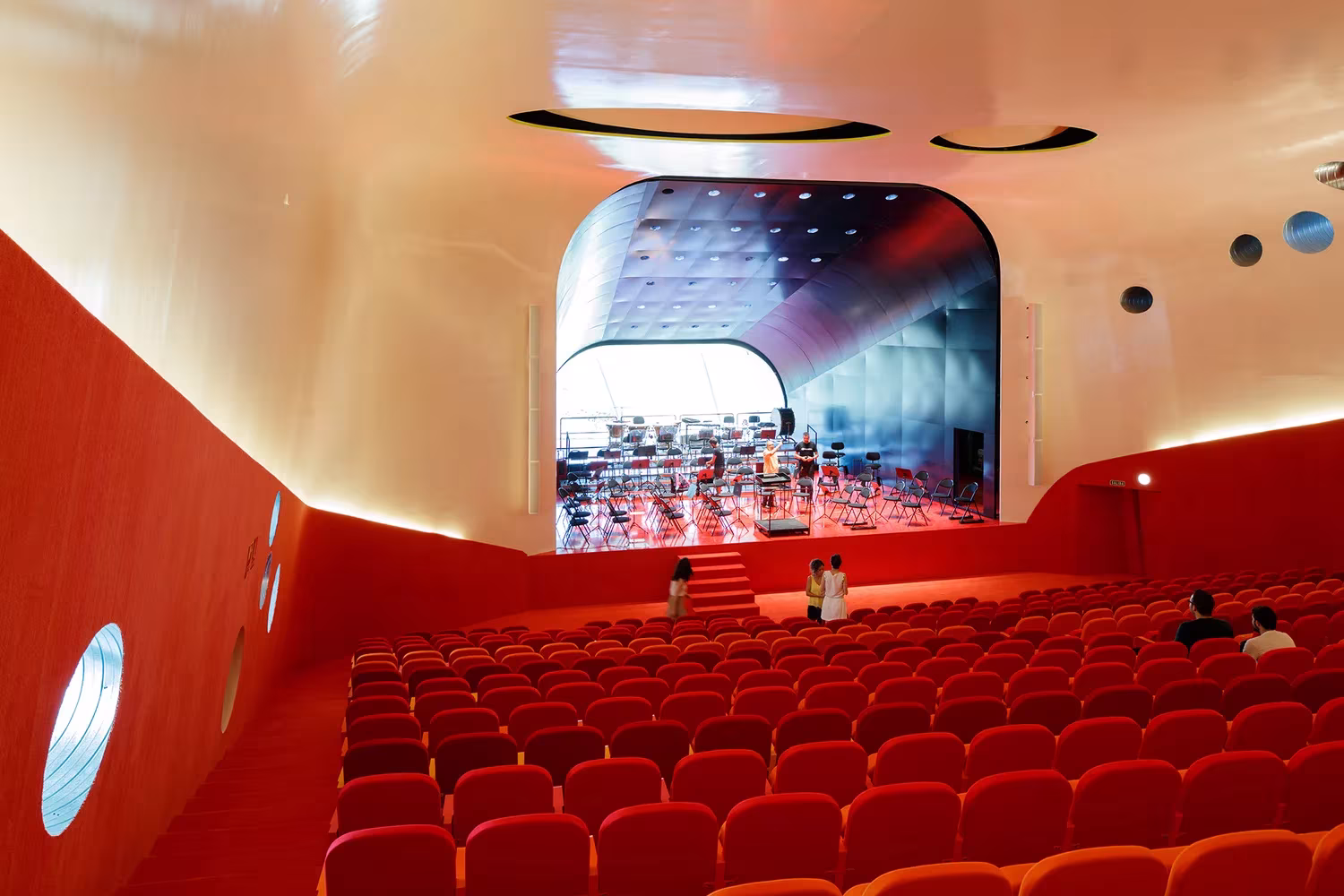 Sala del auditorio del Palacio de Congresos de Plasencia con butacas y paredes rojas y techo blanco de Selgas Cano