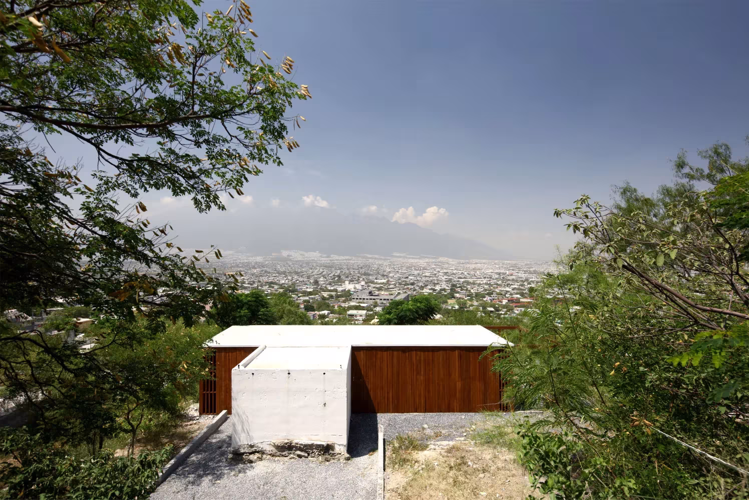 Capilla de la Parroquia de San Rafael Arcángel con cubierta blanca y fachada de madera sobre la ciudad de Monterrey