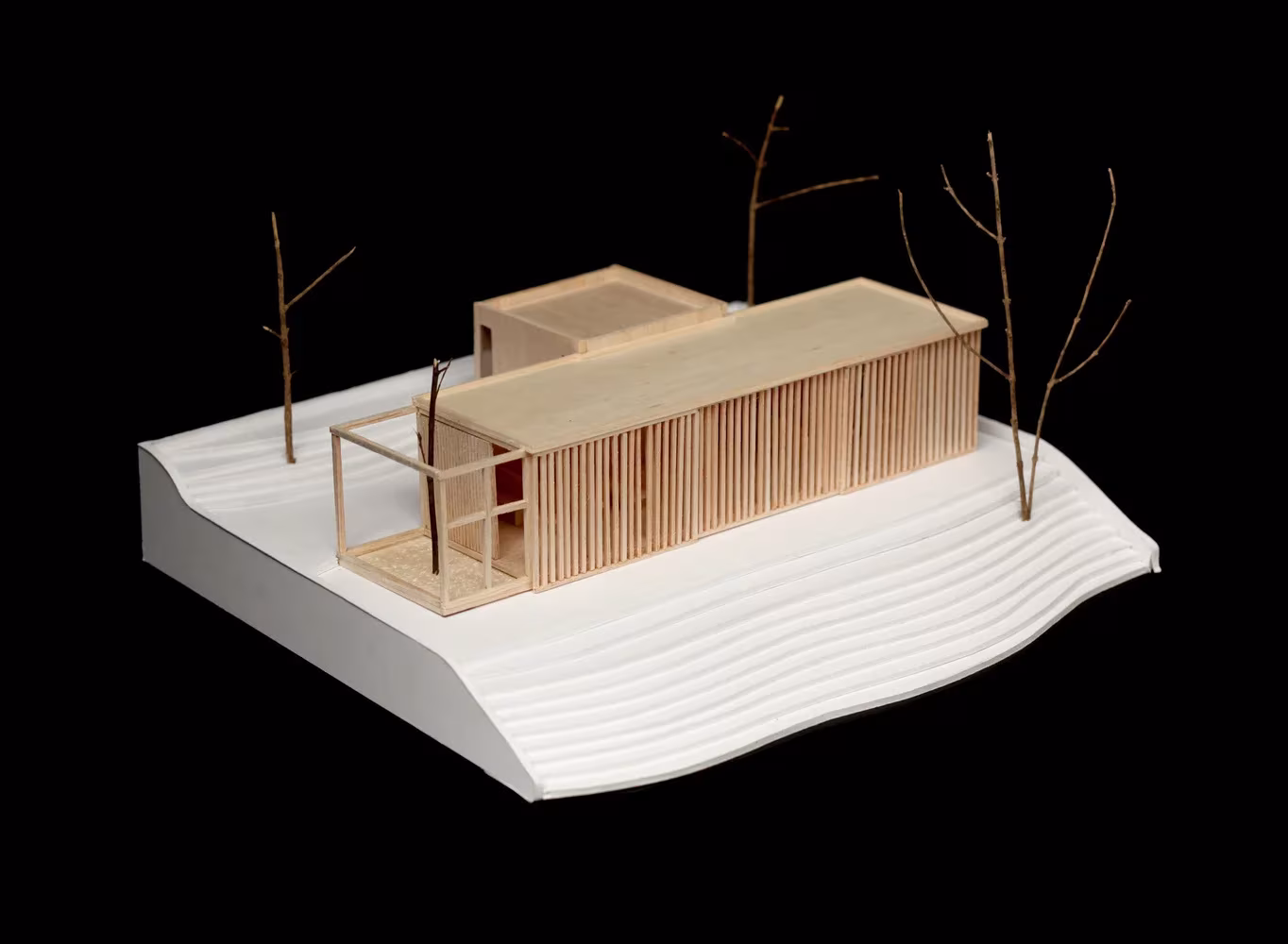 Maqueta de la nave de listones de madera de la Parroquia de San Rafael Arcángel con árboles de ramas secas