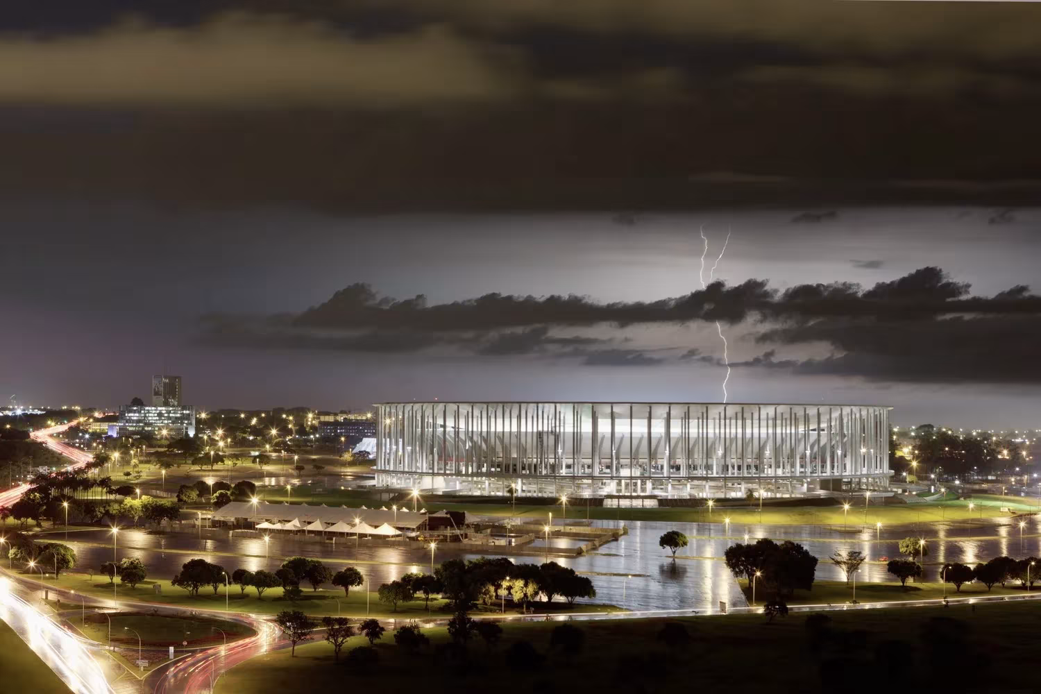 Estadio Nacional Mané Garrincha de Brasilia iluminado de noche bajo una tormenta con rayos, obra de Castro Mello