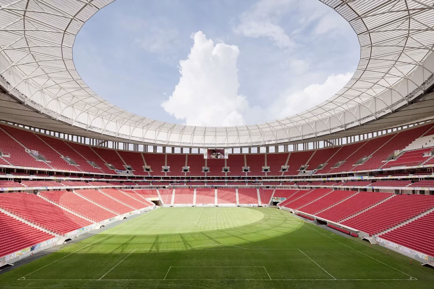 Gradas rojas y anillo de cubierta abierto al cielo en el interior del Estadio Mané Garrincha de Brasilia