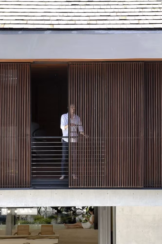 Celosía de lamas de madera corrida y barandilla en el piso superior de la Courtyard House, en Singapur