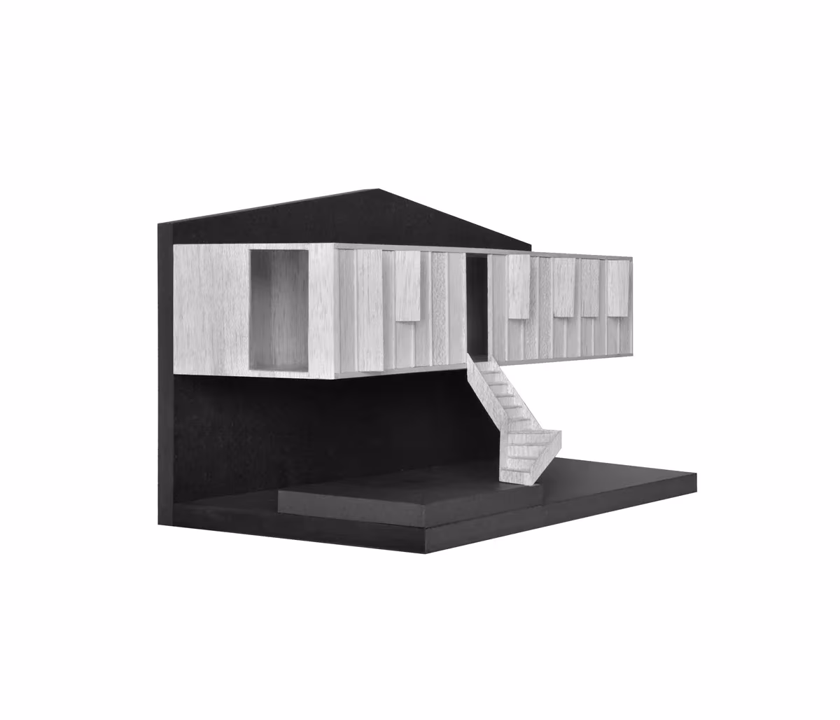 Maqueta en blanco y negro de la casa de DataAE, con el volumen superior sobre la planta baja y la escalera