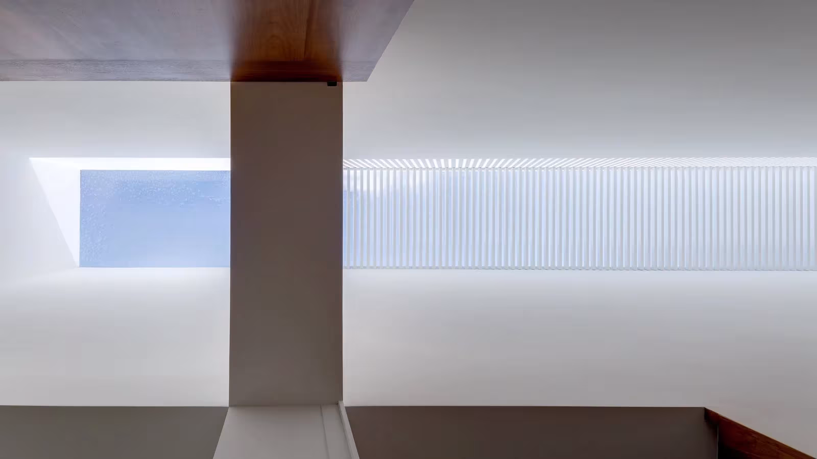 Lucernario con lamas blancas junto a un pilar en el techo de la Casa Jardín 58 de DCPP Arquitectos
